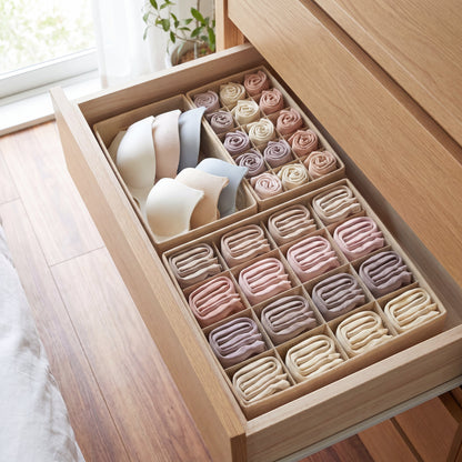 Caixas organizadoras de tecido creme dividindo a gaveta em compartimentos arrumados
