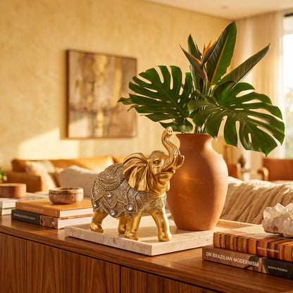 Escultura elefante da sorte dourado com vaso e livros na decoração da sala