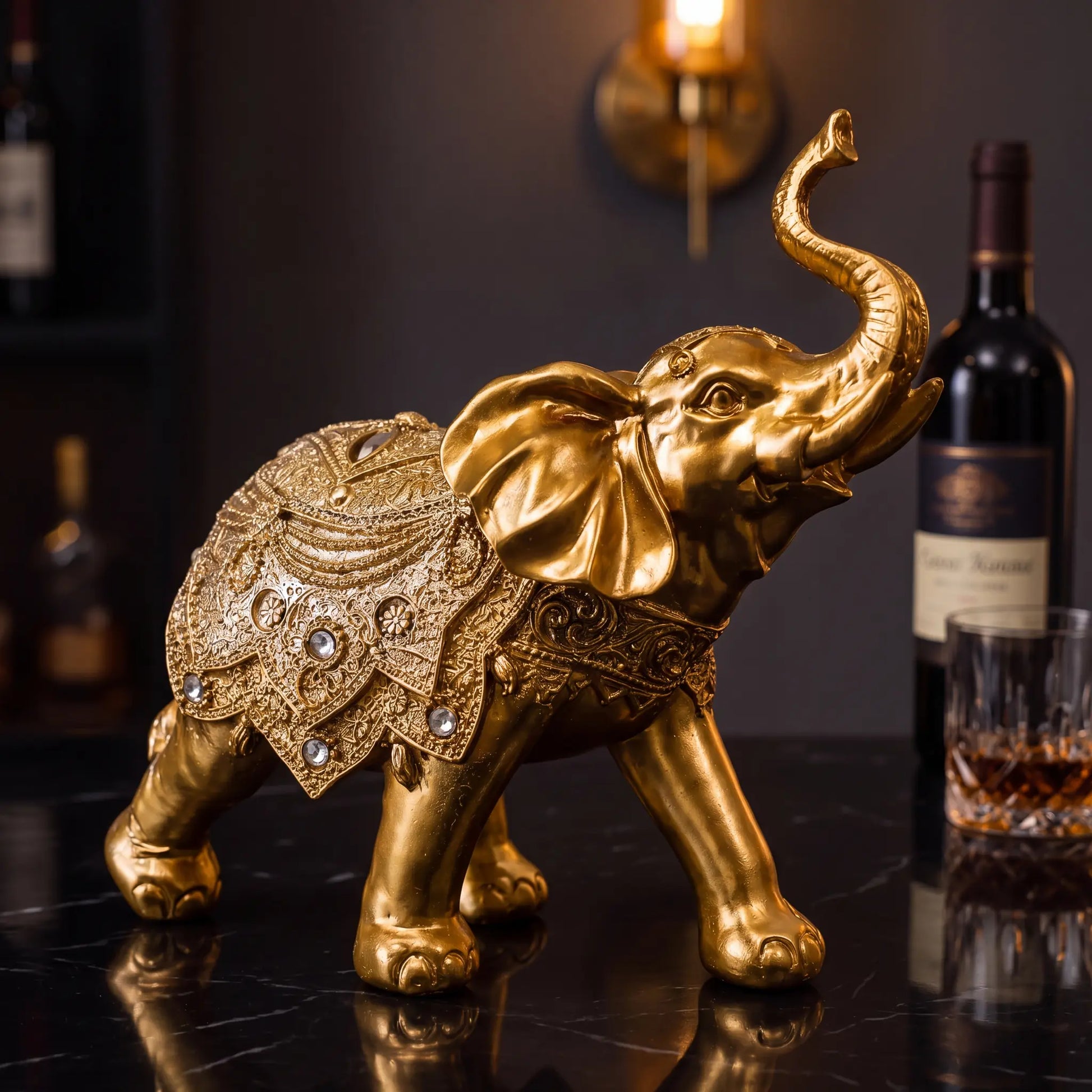 Escultura elefante da sorte dourado em ambiente de bar com vinho e luz âmbar