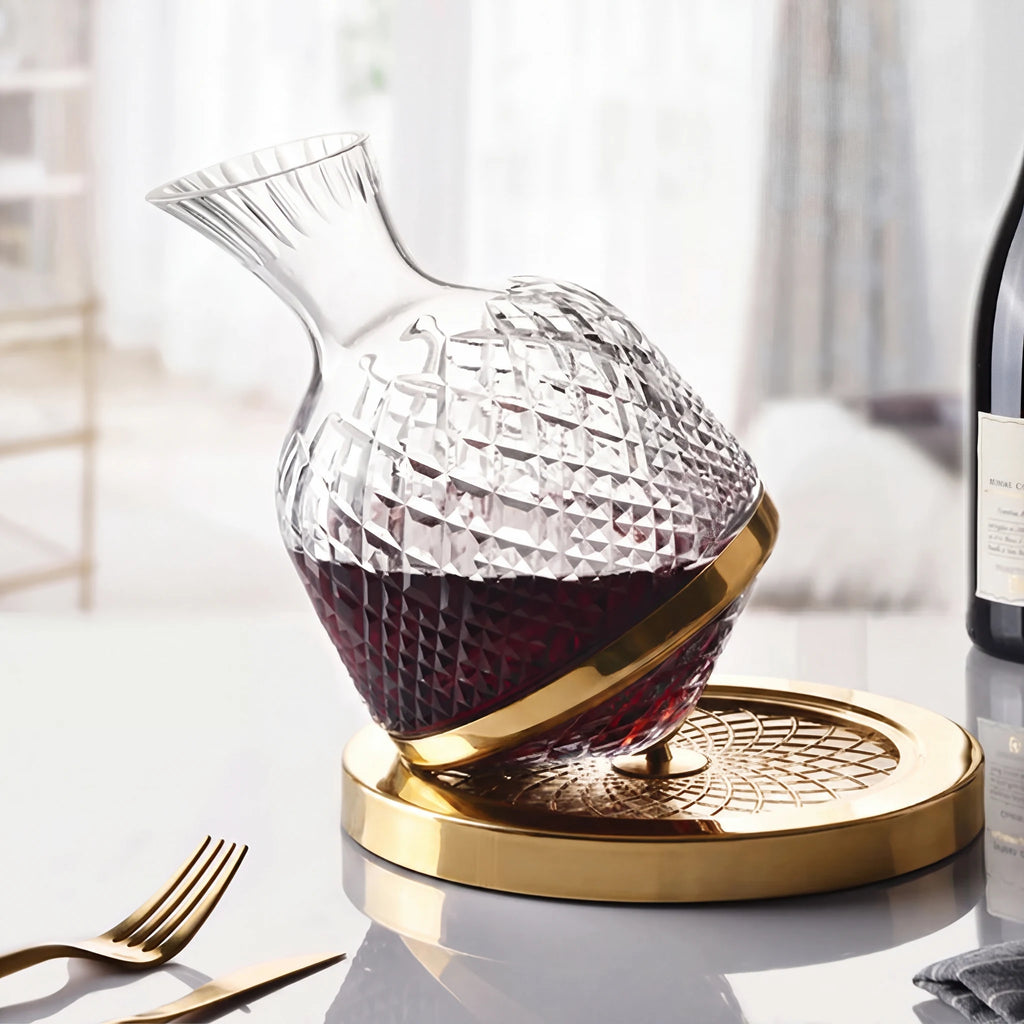 Decanter Vórtice giratório dourado com vinho tinto sobre mesa posta clara