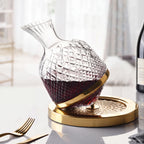 Decanter Vórtice giratório dourado com vinho tinto sobre mesa posta clara