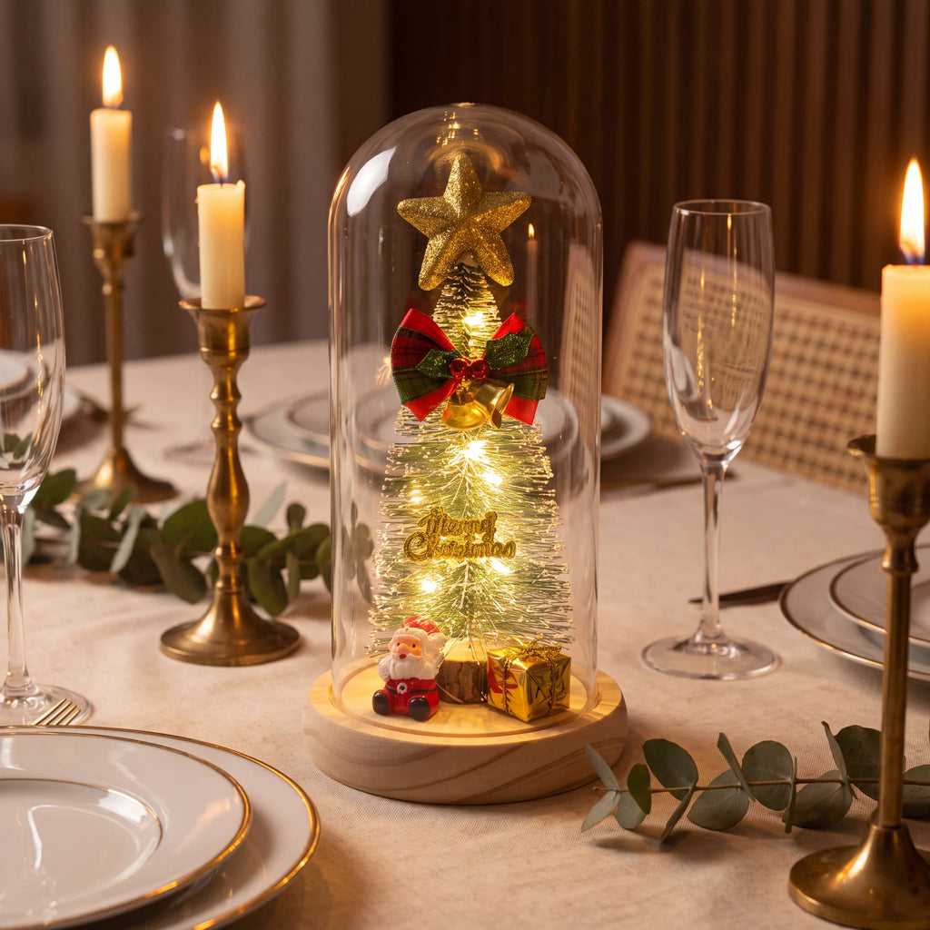 Luminária de Natal acesa no centro de mesa posta com velas douradas, taças de cristal e eucalipto