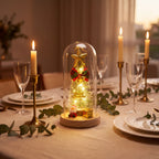 Luminária de Natal iluminando mesa de jantar posta ao fim de tarde com velas e folhagem verde