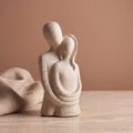 Escultura casal abraçado com fundo terracota e tecido de linho