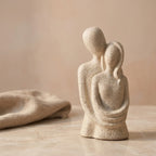 Escultura casal abraçado sobre superfície de mármore com linho