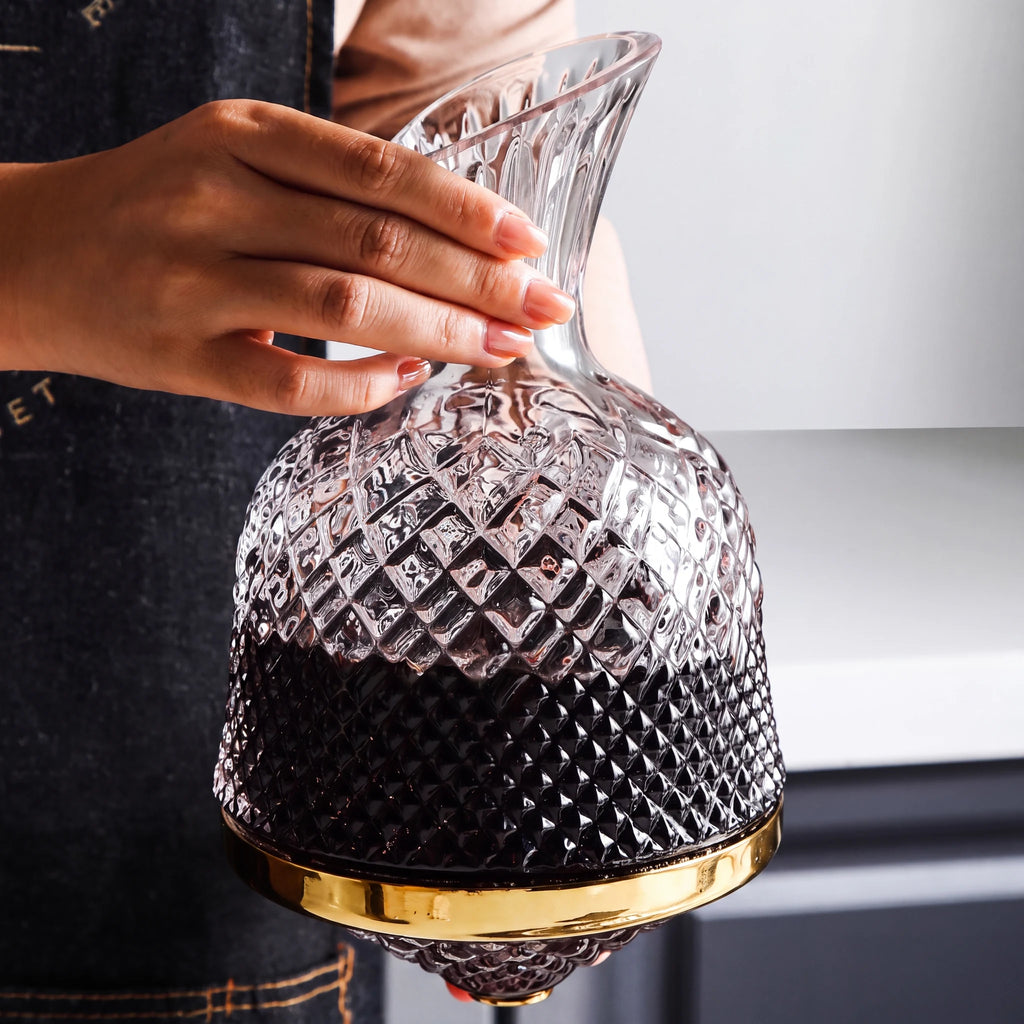 Decanter Vórtice cheio de vinho tinto segurado pelo gargalo, lapidação em diamante